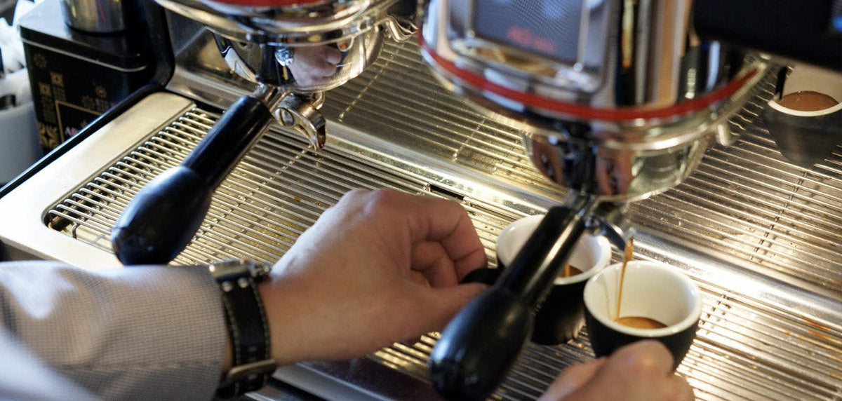 Espresso coffee pouring into two espresso cups