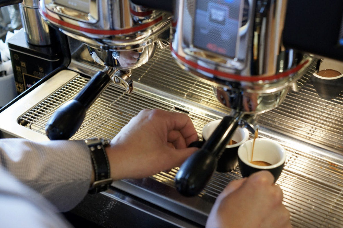 Espresso coffee pouring into two espresso cups